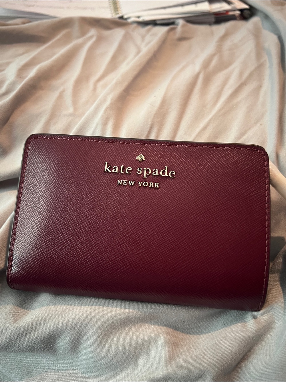 kate spade burgundy saffiano leather wallet with gold logo
